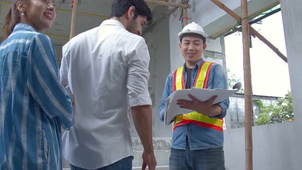 Young Asian engineers and caucasian engineer colleagues at site inspector and discuss together