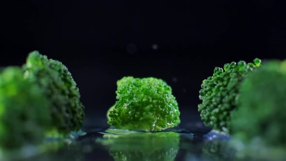 A drop of water falling in slow motion on Broccoli
