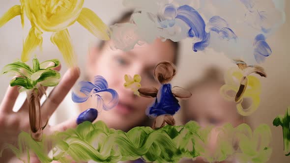 A child with mom draw paints on glass alt