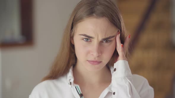 Portrait of Confident Carefree Cute Woman with Different Colored Eyes Looking at Camera Indoors alt