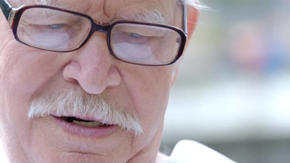 An Old Grandfather with a Gray Mustache and Glasses He Angrily Speaks to the Camera alt