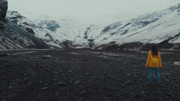 Woman standing in big snowy valley alt
