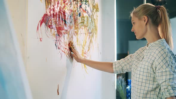 A Woman is Using Her Both Hands to Paint on a Wall alt