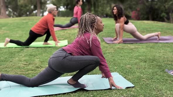 Multiracial people doing yoga exercise with social distance for coronavirus outbreak at park