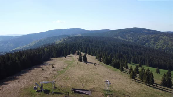 Aerial View From A Meadow in the Middle of a Dense Spruce Forest in a Spring Mountain Landscape