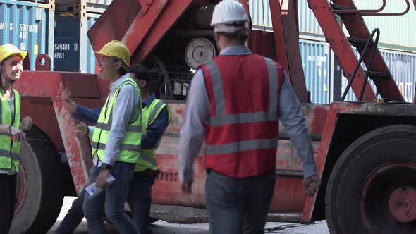 Funny workers and engineer dance at cargo containers