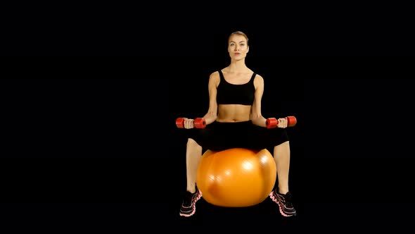 Sport Sitting on Pilates Ball and Exercising with Dumbbells. Alpha Channel. alt