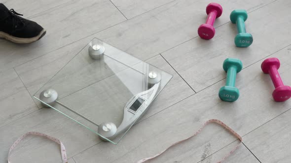 Close up of fat women legs weighing on scales for checking body weight in fitness room alt