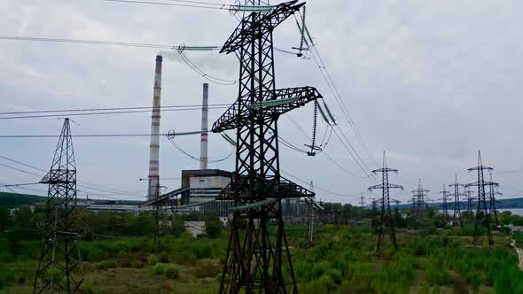 Electricity pylons and high-voltage power lines on the green grass. Power plant. alt