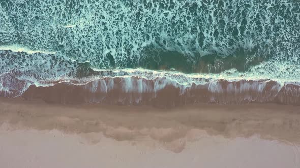Aerial view of waves crash to shore