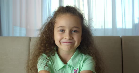 Portrait Honey Little Girl Smiling Child Looking at Camera are Sitting on the Couch at Home Cute Kid alt