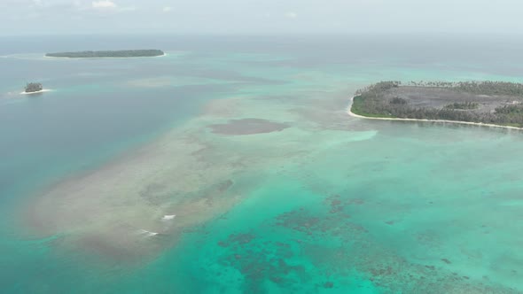 Aerial: flying over coral reef tropical islands caribbean sea turquoise blue alt