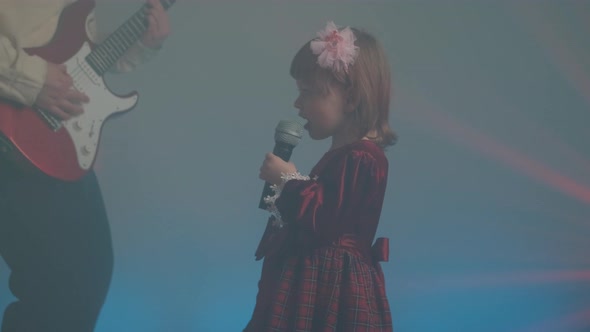 Little Girl in Vintage Dress Sings on Stage Her Father Plays an Electric Guitar