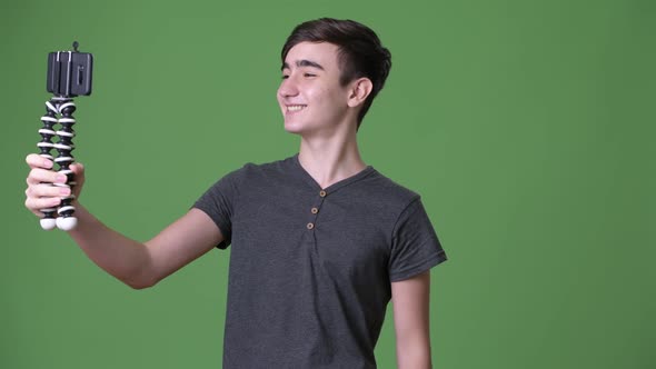 Young Handsome Iranian Teenage Boy Against Green Background alt