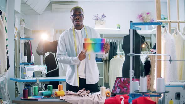 African Tailor is Explaining Colour Spectrum for the Camera alt