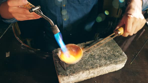 Goldsmith Is Inflaming a Piece of Jewelry in a Tiny Plate. Jeweler Working Jewelry alt