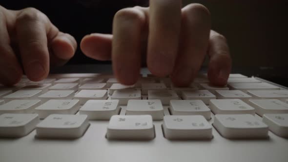 Close-up typing on keyboard with man fingers. Macro soft focus dolly shot. alt