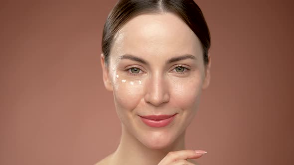 Young Woman with Cream Dots Under Eye