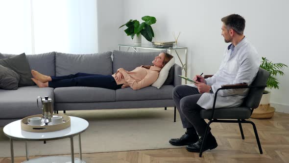 Smiling Woman with Mental Health Problems Lying on Couch Talking to Therapist alt