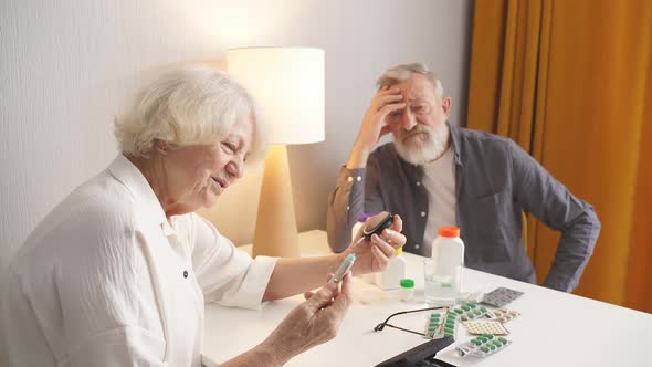 Senior Person with Glucometer Checking Blood Sugar Level at Home
