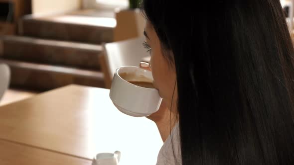 Woman Drinks Coffee at the Cafe