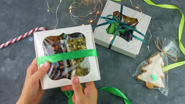 Girl wraps Christmas gift box natural dried fruits nuts individually wrapped set Healthy food snack alt