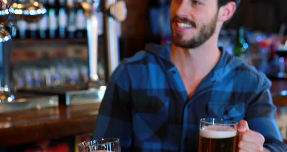 Friends interacting while toasting glasses of beer alt