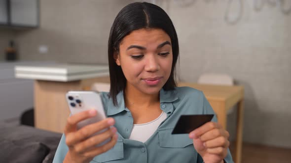 Young African American Woman Holding Smartphone and Credit Card Received Rejection