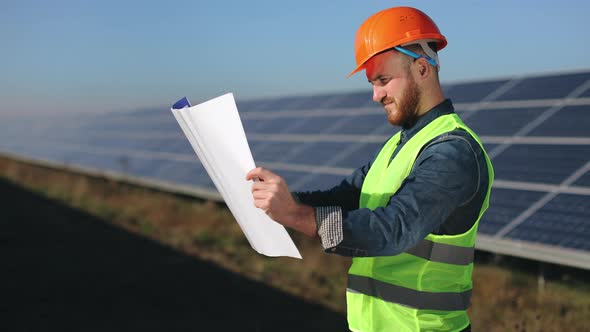 The Engineer is Looking at the Project Drawings alt