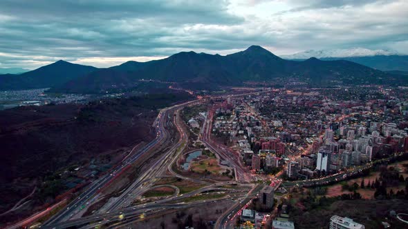 Aerial view dolly in of the commune of Vitacura the Manquehue hill in the background with clouds, Sa alt