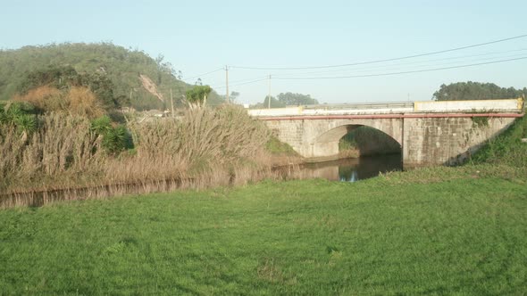 Greenery Landscape By The Calm River Over County Arch Bridge At Alcobaca River Near Nazare, Portugal alt