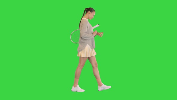 Girl Using Modern Smart Watch While Walking on a Green Screen Chroma Key