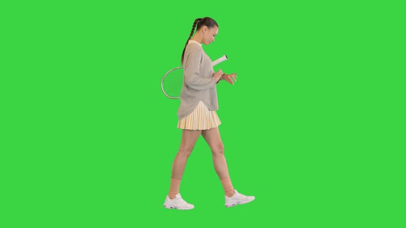 Girl Using Modern Smart Watch While Walking on a Green Screen Chroma Key alt