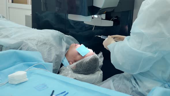 Doctor is Working with a Patient During Eye Surgery alt