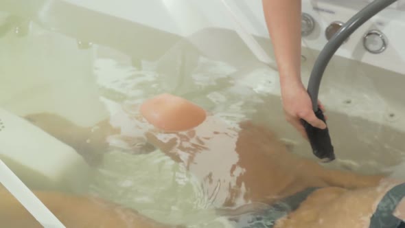 Sliding Cropped Shot of a Gorgeous Woman Enjoying Hydromassage at Spa Center alt