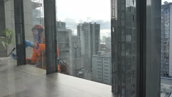Industrial Climber Washes the Facade Glazing in Rubber Gloves. Protection From the Coronavirus alt