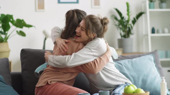 Happy Women Taking Medical Masks off, Smiling and Embracing at Home alt
