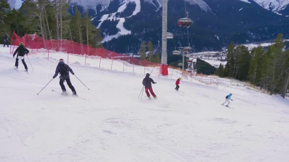 Skier Skiing and People on Snowboards Ride Down the Slope on Ski Resort in Mountains Winter. alt