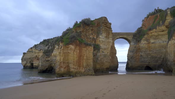 Praia dos estudantes beach with arch bridge in Lagos, Portugal alt