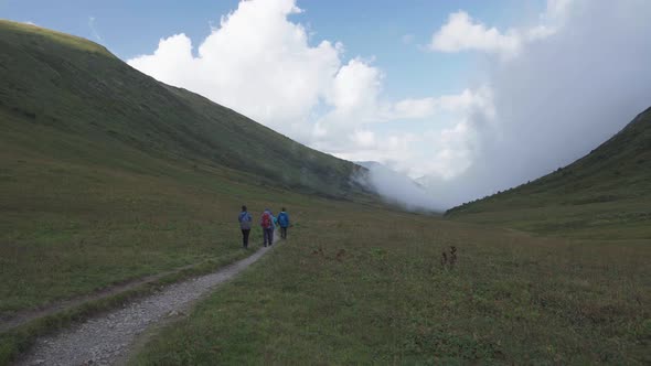 Bzerpinskiy Karniz, a Group of Hikers Walking Down a Mountain Trail alt