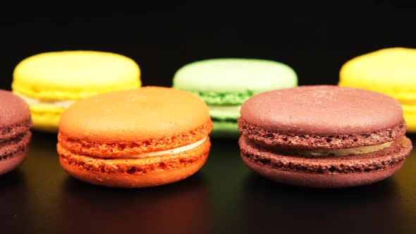 A rows of a colorful macaroons is on the black table