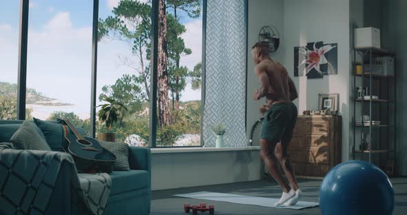 African American Athlete Doing Workout at Home Looking Out the Huge Window with a Beautiful View