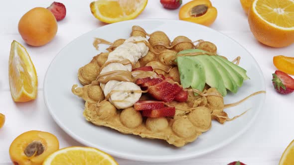 Waffles Decorated with Fruits and Berries on a White Wooden Background Top View alt