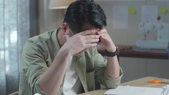 Close Up Of Asian Man Designer Is Upset Failing Sketching Hand Bag On The Layout Bond At The Office alt