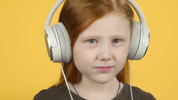 Close-up Baby Listening To Music in Big Headphones, Slow Motion alt