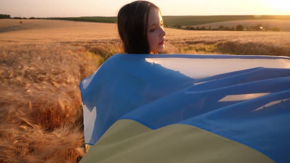 Pray for Ukraine. Child with Ukrainian flag in wheat field.