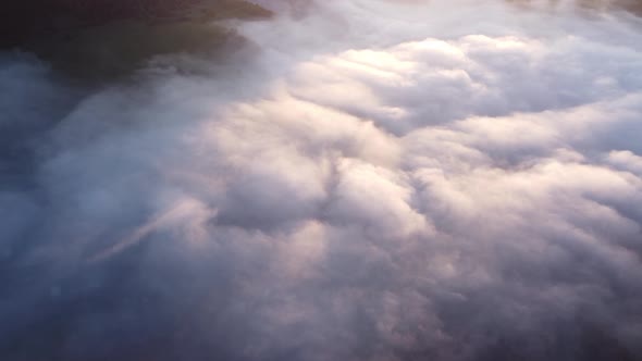 Aerial Top View of Inverse Cloud Cover in the Light of the Morning Sun Misty Landscape