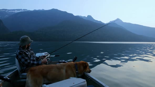 Fisherman fishing with his dog in the river 4k alt