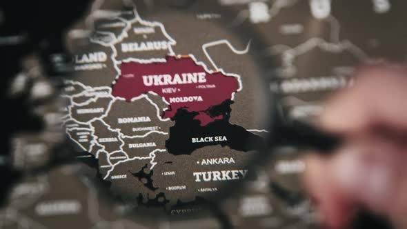 Ukraine on the World Map Under Magnifying Glass alt