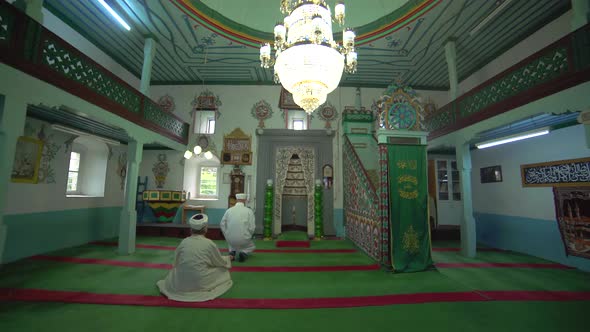Muslim Mosque Teacher in a Robe and Turban at the Small Historic Wooden Masjid